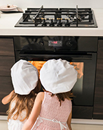 Two_girls_watching_gas_oven-1 Outdoor cooking with dining table and overlooking view